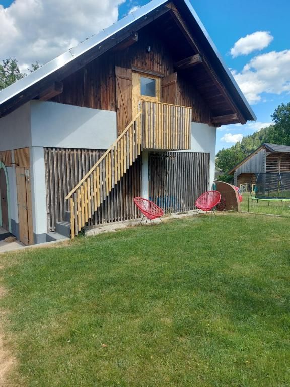 Zunanjost hiše z lesenim stopniščem in zelenico